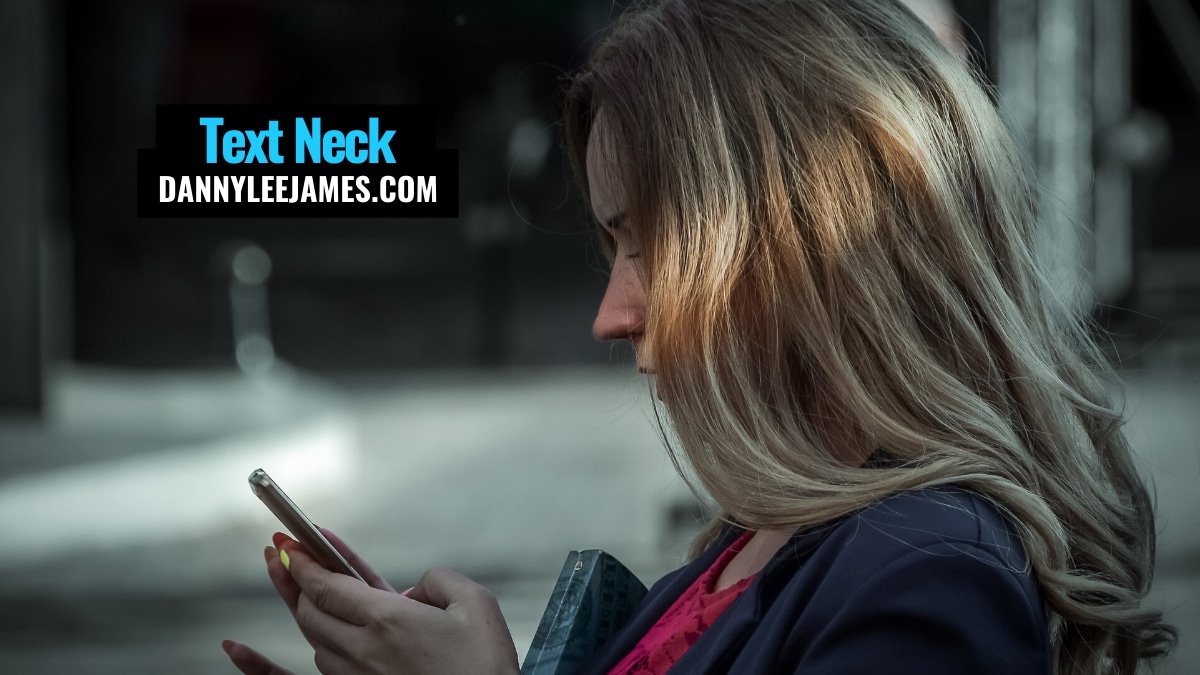 Young woman texting on her mobile phone with poor posture and text neck