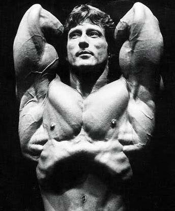 Frank Zane performing a vacuum pose on stage in competition
